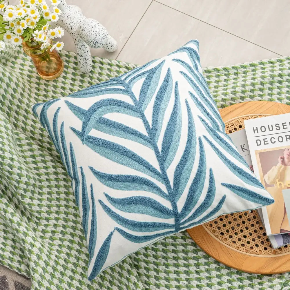 Square cushion cover with embroidered blue palm leaves on white textured fabric from decorbites boho floral collection