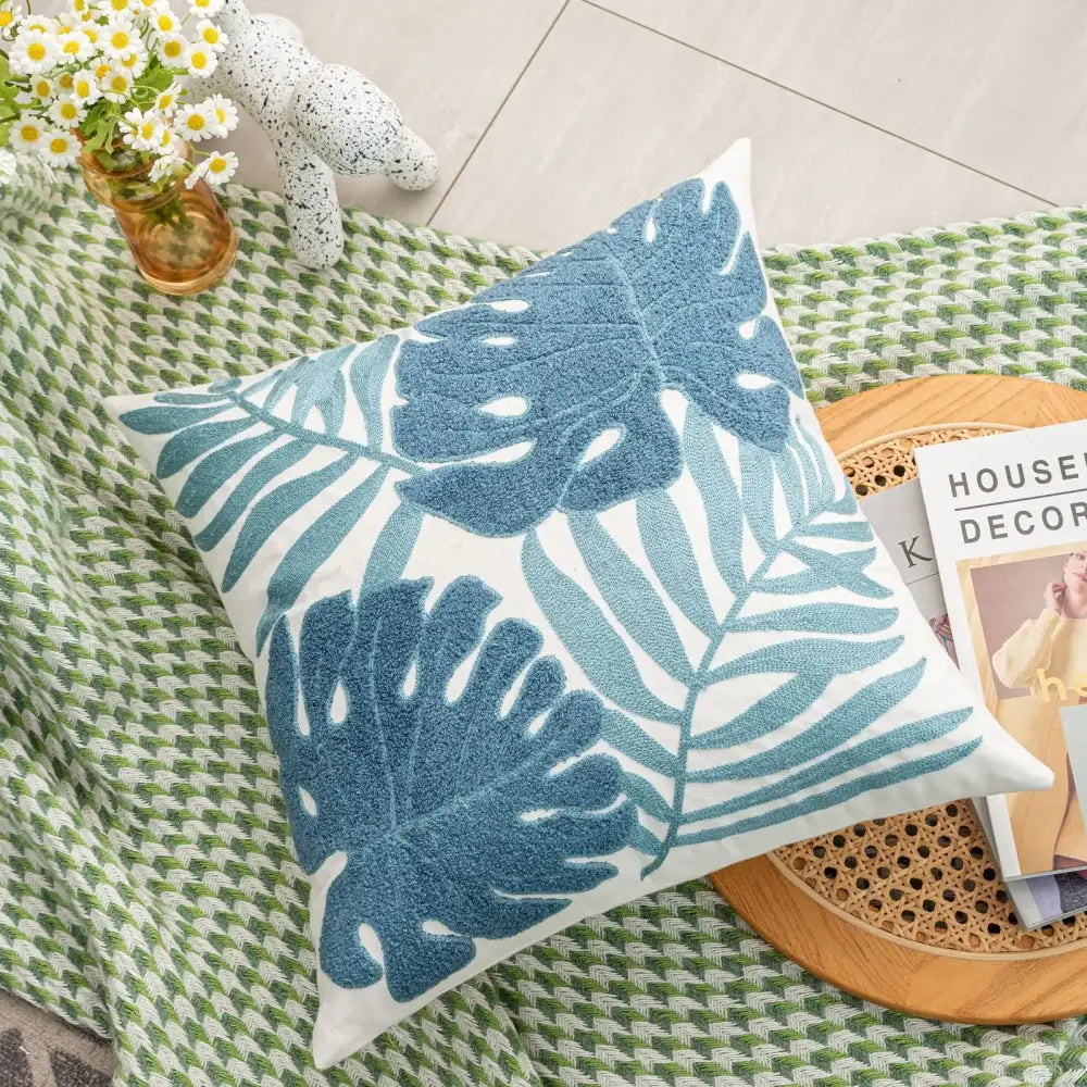 White throw pillow with embroidered blue tropical leaf pattern boho floral embroidered cushion cover decorbites
