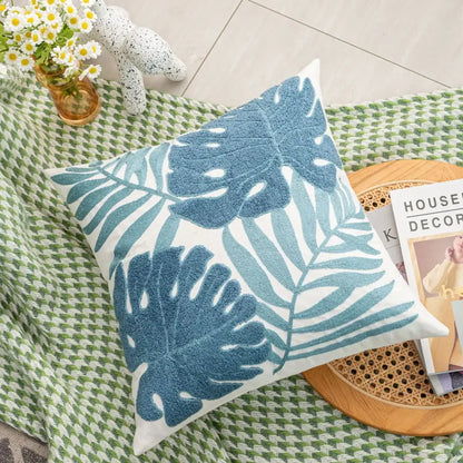 White throw pillow with embroidered blue tropical leaf pattern boho floral embroidered cushion cover decorbites