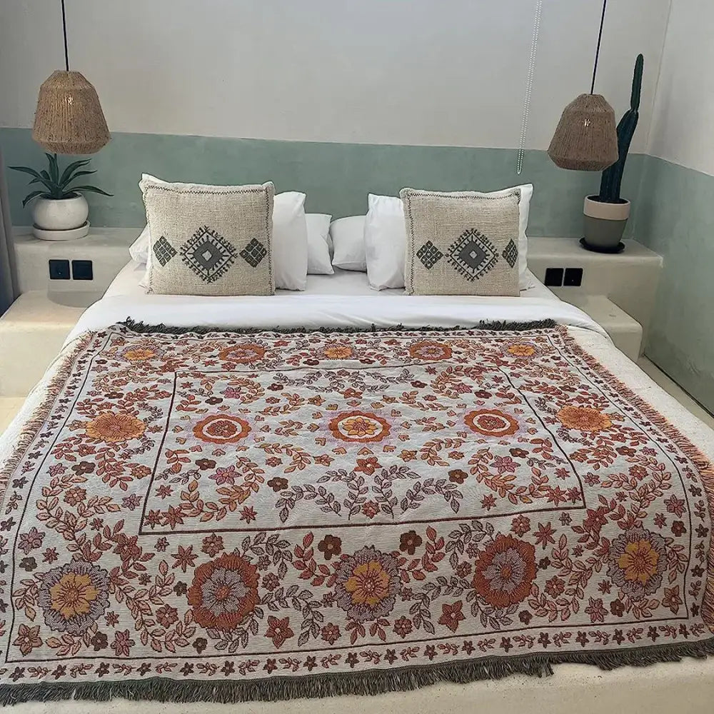 Cream-colored woven boho floral sofa throw blanket with intricate orange and rust floral patterns by decorbites for living room decor