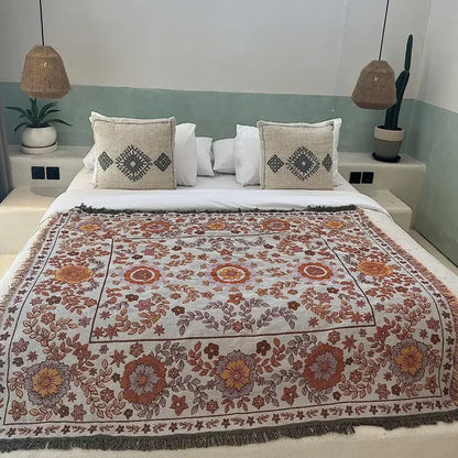 Cream-colored woven boho floral sofa throw blanket with intricate orange and rust floral patterns by decorbites for living room decor