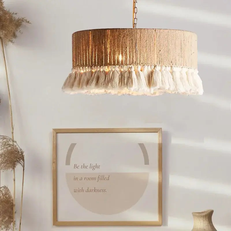 Cylindrical pendant light with textured gold finish and cream tassels in decorbites boho fringe hemp rope style