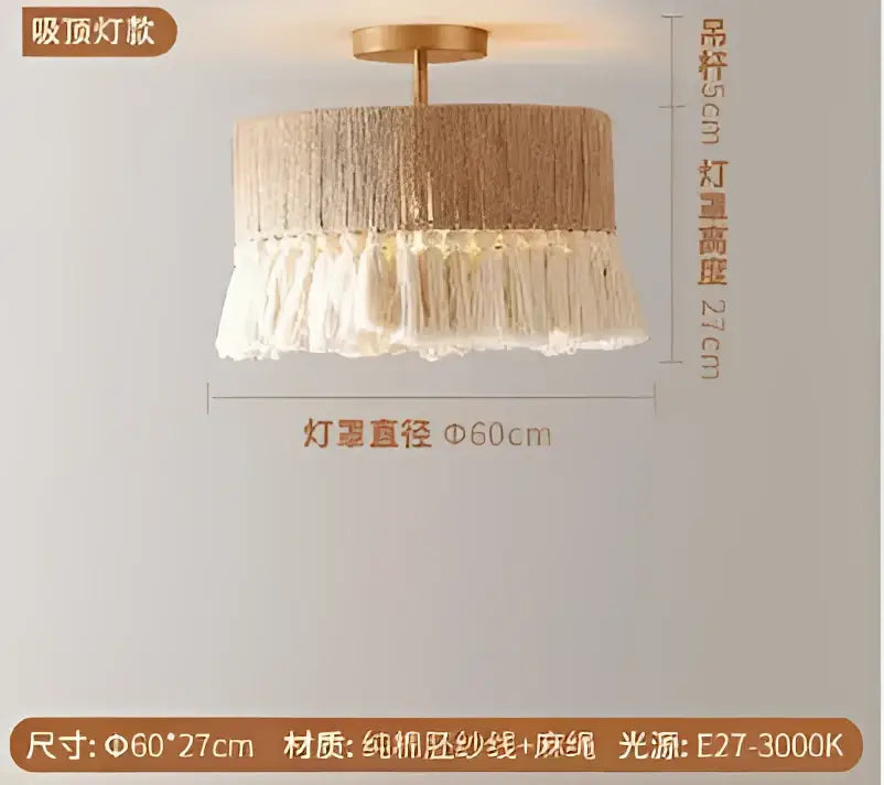 A beige woven pendant light with a fringe of tassels and brass-toned hardware.