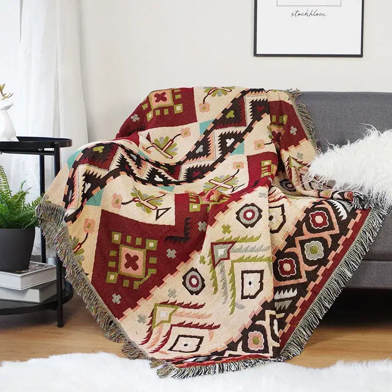 A cozy cream throw blanket with bold maroon black and teal geometric patterns and fringed edges for decorbites geo ethnic decor