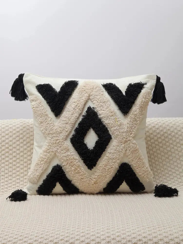 Cream-colored pillow covers with black geometric chenille embroidered tufted patterns and tassels for living room decorbites