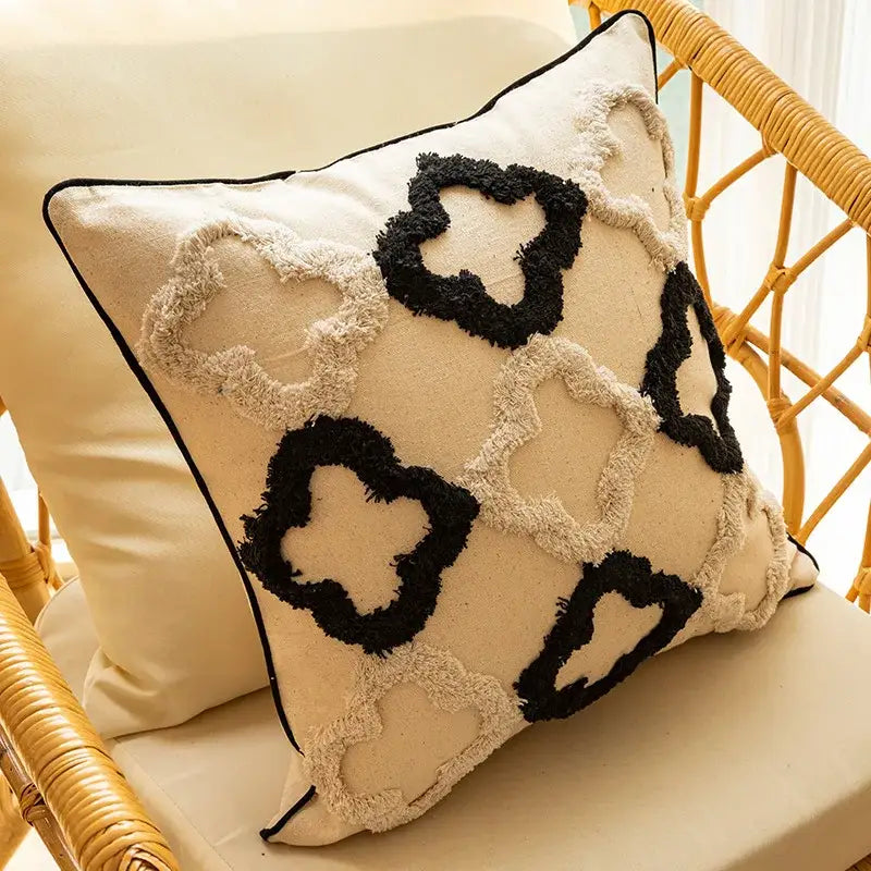 Cream-colored boho geometric chenille embroidered pillow covers with black and cream fringed quatrefoil patterns for living room decorbites