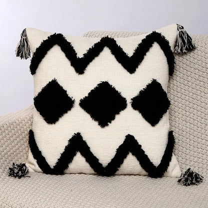 Cream-colored pillow covers with black fringe zigzag and diamond patterns and tassels in decorbites geometric chenille embroidered design