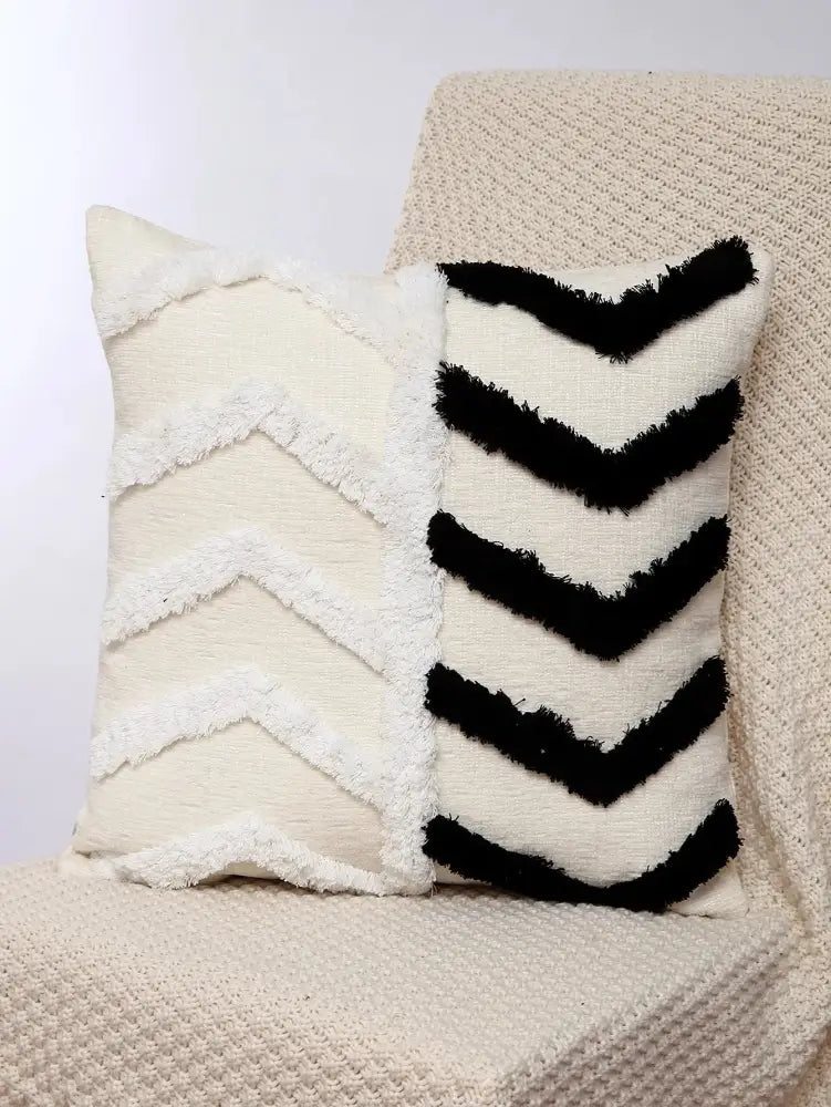 Cream-colored boho geometric chenille embroidered pillow cover with black and white chevron pattern and frayed edges