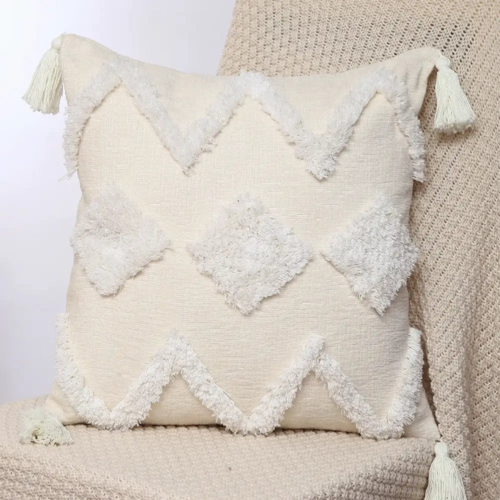 Cream-colored boho geometric chenille embroidered pillow covers with textured fringed diamond and zigzag patterns for decorbites