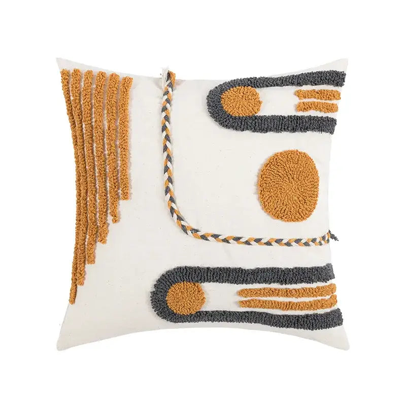 A square white cushion cover with boho geometric embroidered textured tufted designs in mustard yellow and dark gray cotton