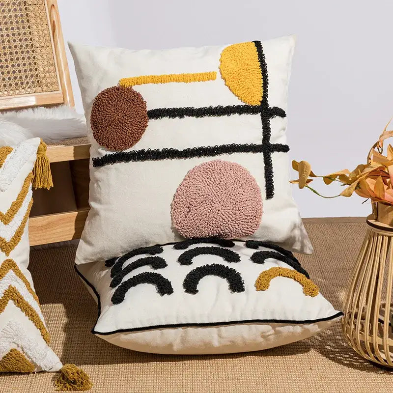 Cream-colored cushion cover with decorbites geometric embroidery in mustard, brown, and black for boho decor