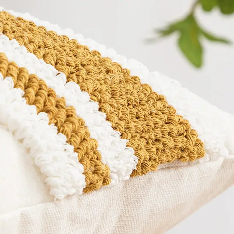 A cozy hand-crocheted cushion cover with bold mustard yellow and white stripes featuring geometric embroidery boho decorbites