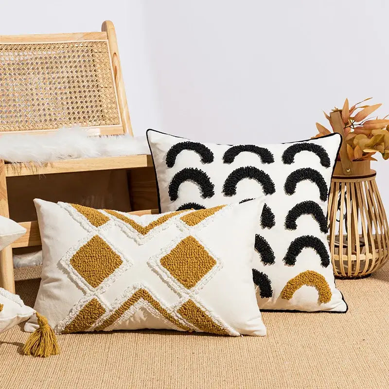 Two textured throw pillows with geometric embroidery boho patterns in cream mustard and black on white cushion cover decorbites
