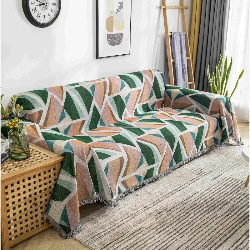 A cozy boho chenille woven throw blanket in green beige and teal geometric pattern with fringed edge for living room decor