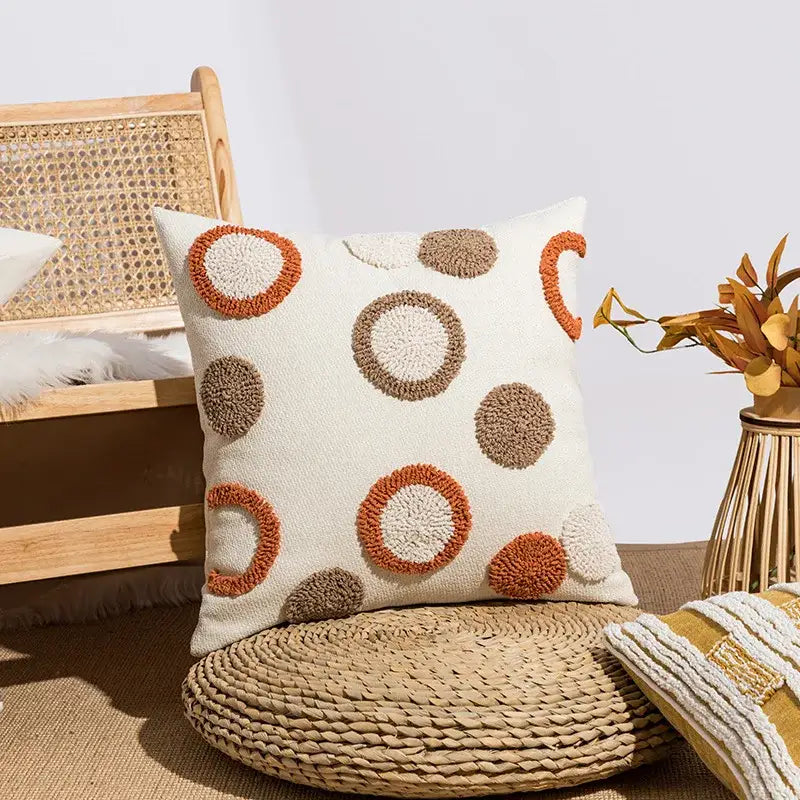 Cream-colored cushion cover with textured embroidered circular patterns in orange and brown for decorbites boho loop tufte decor