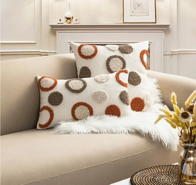 Cream-colored cushion cover with textured orange and brown pom-poms featuring decorbites boho loop tufte design
