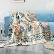 A cream-colored decorbites boho cotton throw blanket with orange and blue geometric patterns for sofa decor