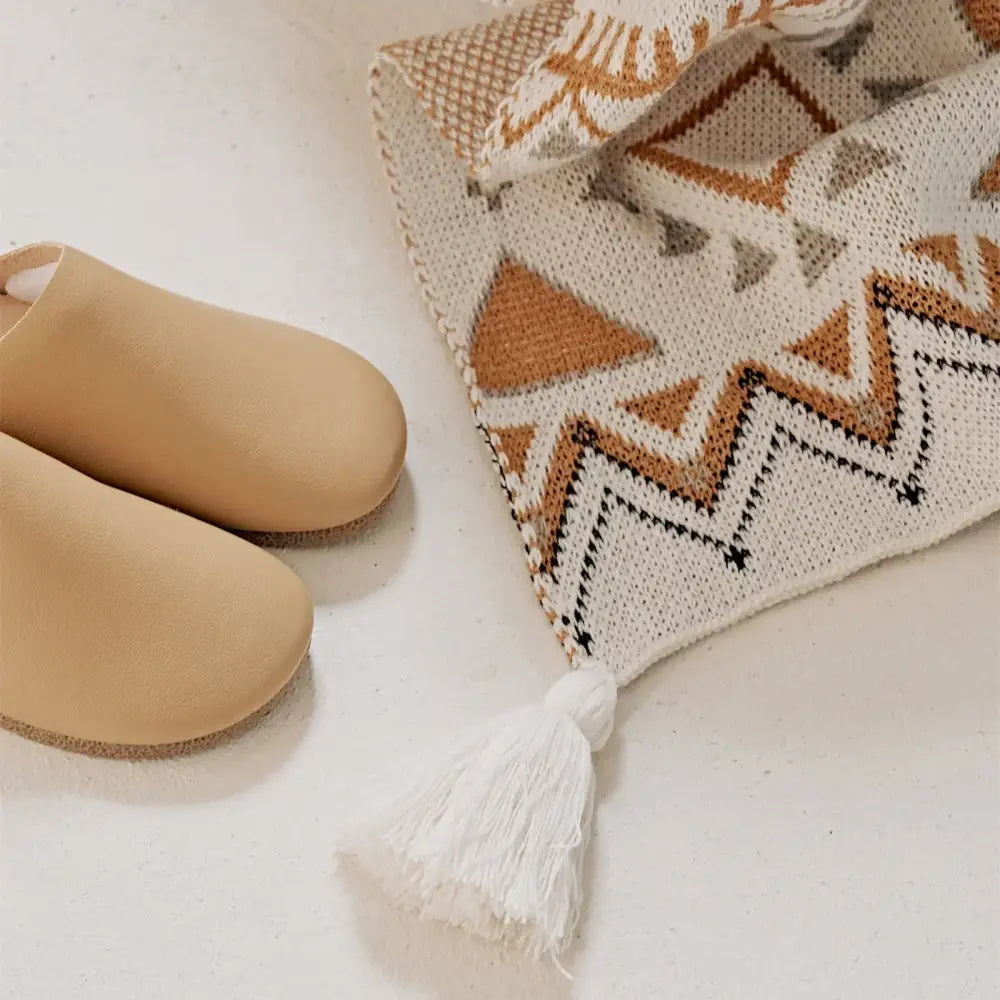 Beige leather clog shoes with a soft, rounded toe and cork sole.