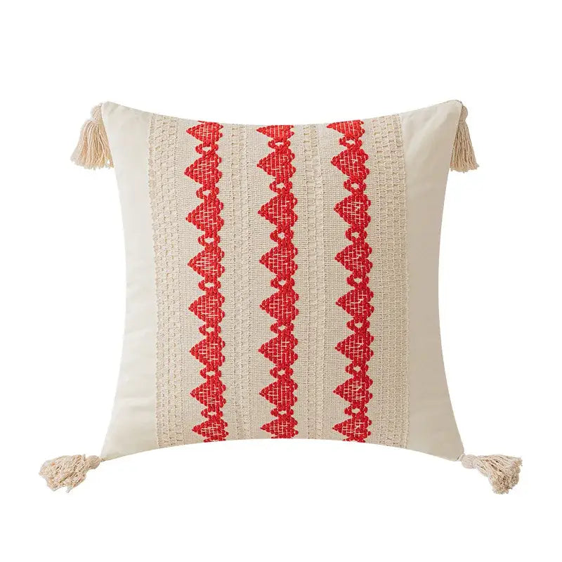 Cream-colored cushion cover with bold red boho geometric tassel embroidery and corner tassels by decorbites for living room decor