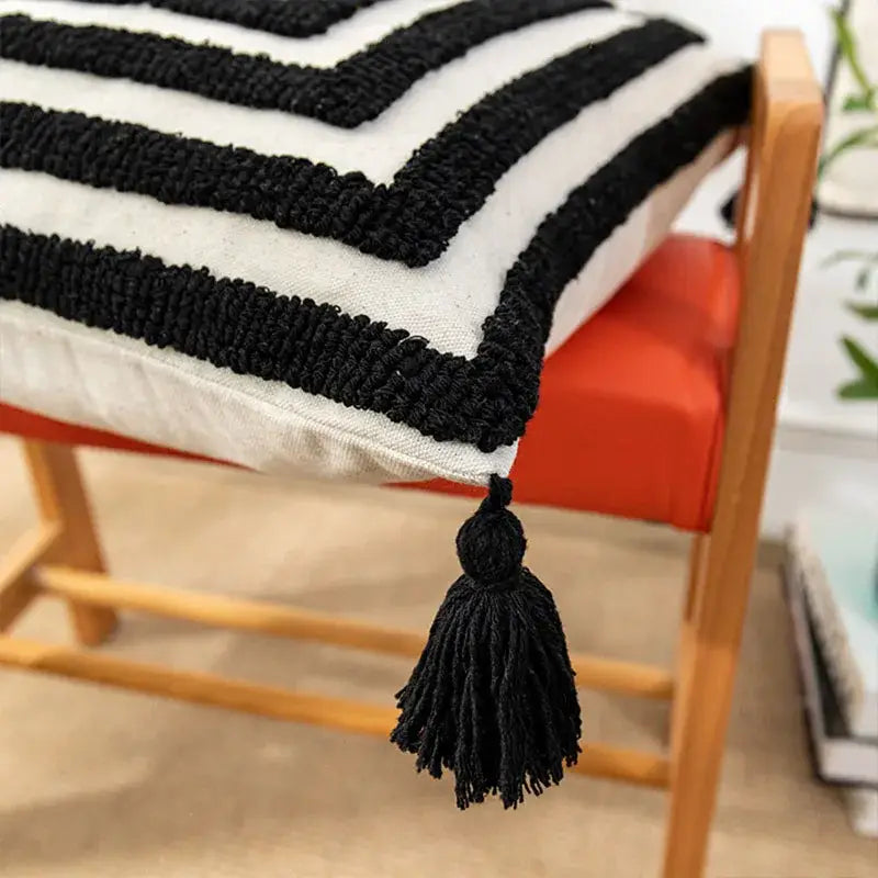 Boho geometric tufted black and cream cushion cover with textured chunky knit stripes and black tassel for living room decor