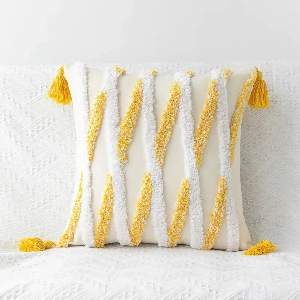 Cream-colored decorbites boho geometric tufted cushion cover with textured white and yellow tassels and fringe accents