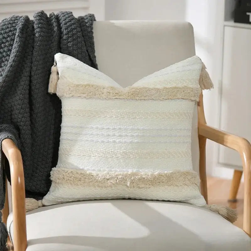 Cream-colored woven boho geometric tufted cushion cover with textured stripes and fringed tassels for living room decorbites