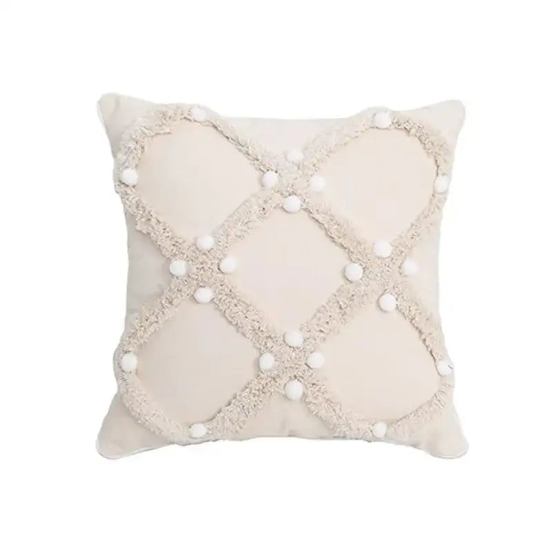 Beige cushion cover with textured frayed crosshatch and white pom-poms decorbites boho geometric tufted pillow