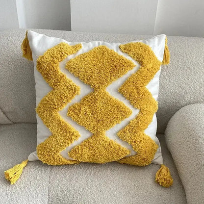 A vibrant yellow and white boho geometric tufted cushion cover with fluffy tassels for living room decorbites decor