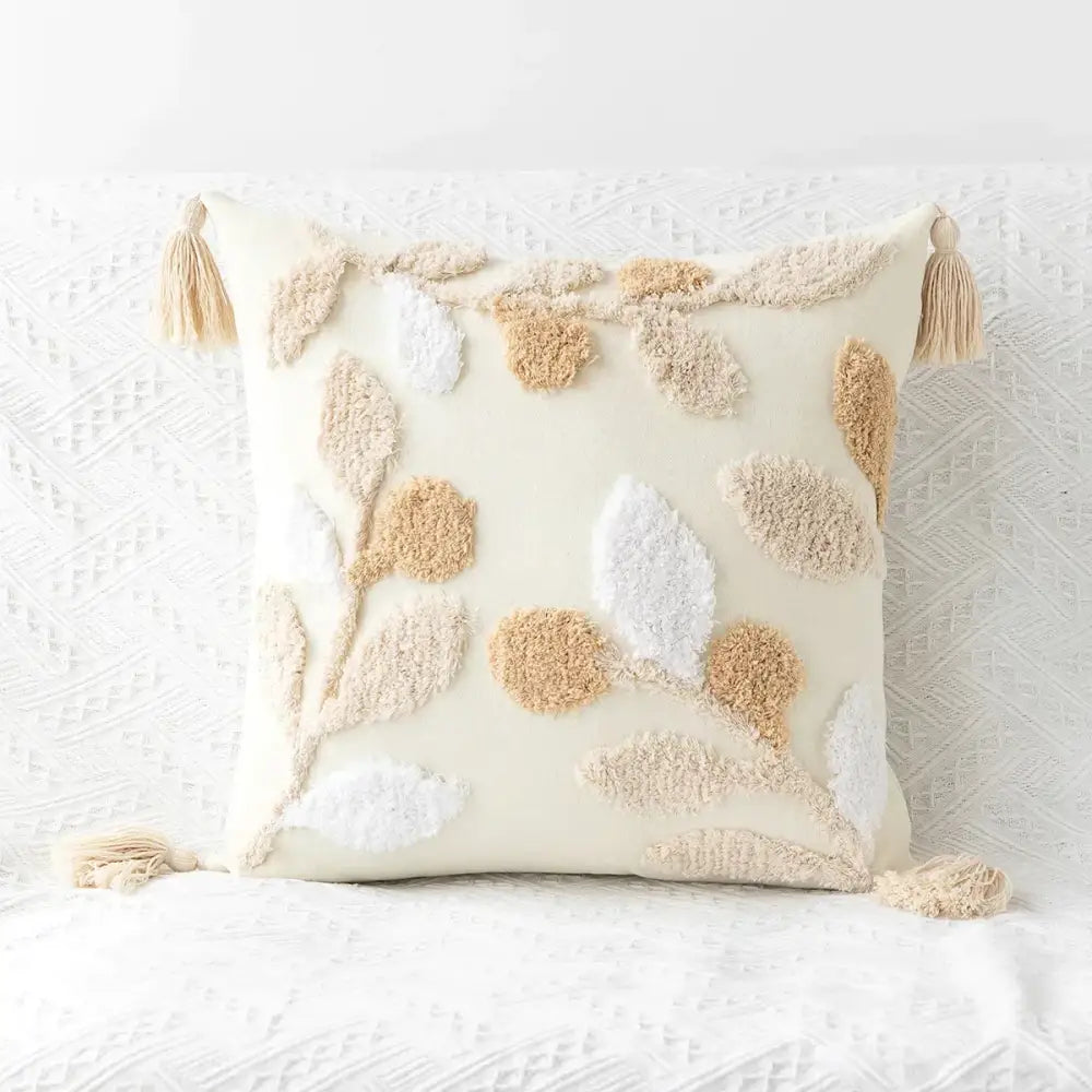 Cream-colored boho geometric tufted cushion cover with textured embroidered leaf and berry motifs and tassels for living room decorbites
