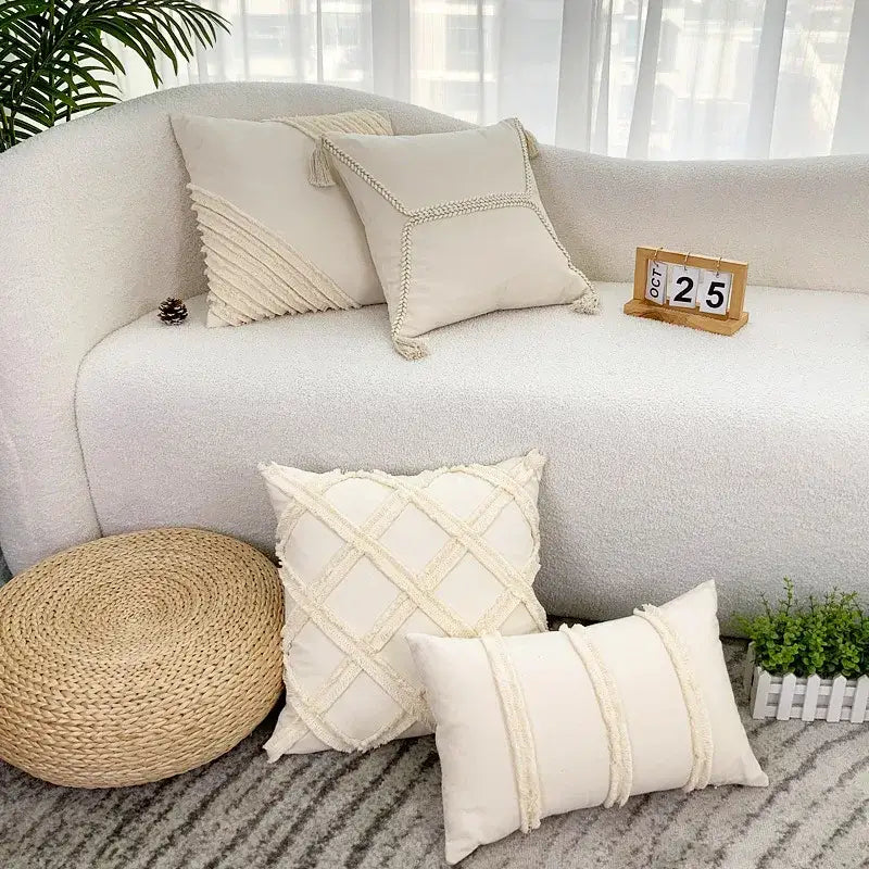 Cream-colored boho geometry fringed cushion cover with textured woven patterns and tassels on a cozy sofa decorbites
