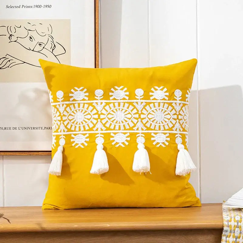 Vibrant yellow boho gold embroidered cotton pillow cover with intricate white patterns and tassels by decorbites