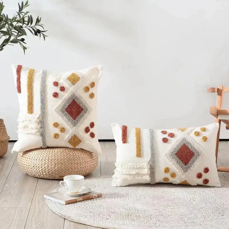 Two cream-colored boho ivory brown textured pillow covers with rust mustard and gray geometric decorbites boho ivory accents