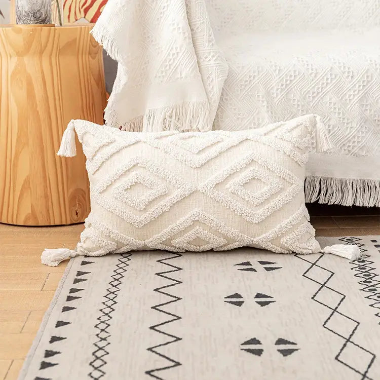 Cream-colored boho ivory cotton loop cushion cover with textured diamond zigzag patterns and tasseled corners for decorbites