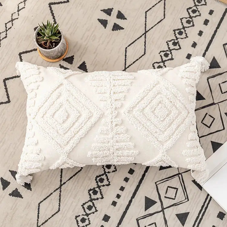 Cream-colored rectangular cushion cover with textured geometric embroidery and tasseled decorbites ivory cotton loop design