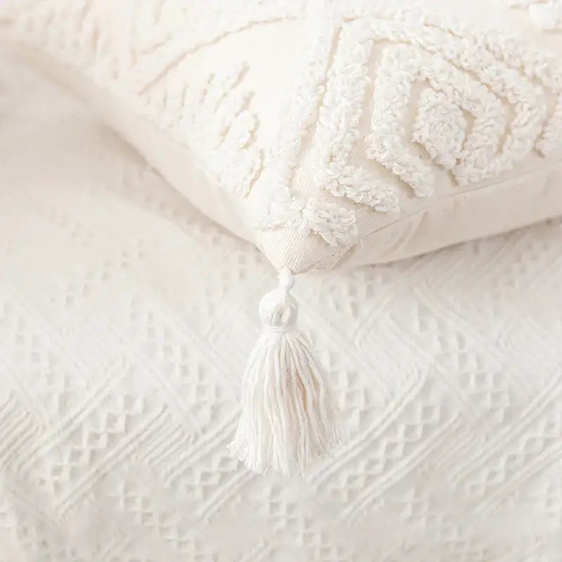 Cream-colored decorbites ivory cotton loop cushion cover with textured tufted pattern and tasseled corner for living room decor
