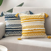 Two textured decorbites boho jacquard cushion covers in navy blue white and mustard yellow cream with tassels