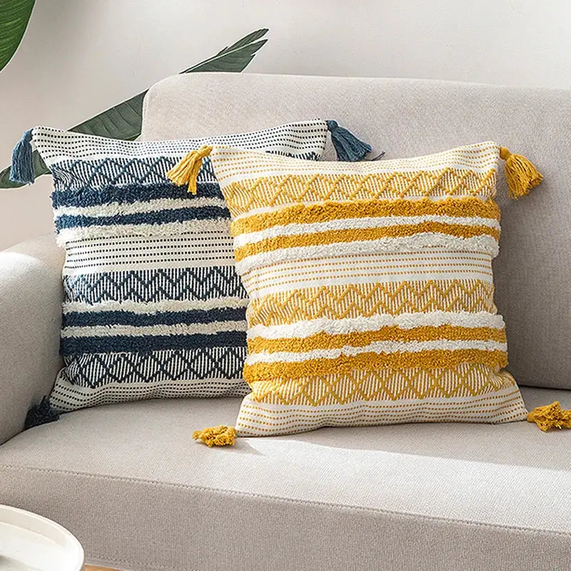 Two textured decorbites boho jacquard cushion covers in navy blue white and mustard yellow cream with tassels