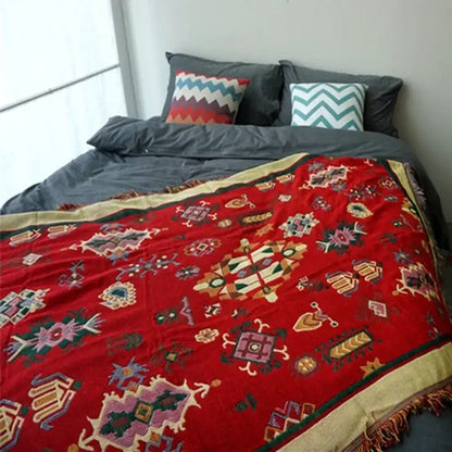 Vibrant red throw blanket with intricate geometric floral patterns and gold-trimmed fringed edges decorbites boho jacquard knitted