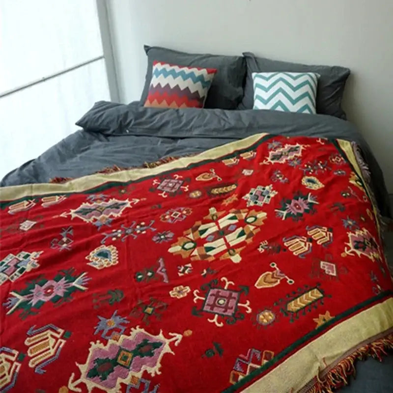 Vibrant red throw blanket with intricate geometric floral patterns and gold-trimmed fringed edges decorbites boho jacquard knitted