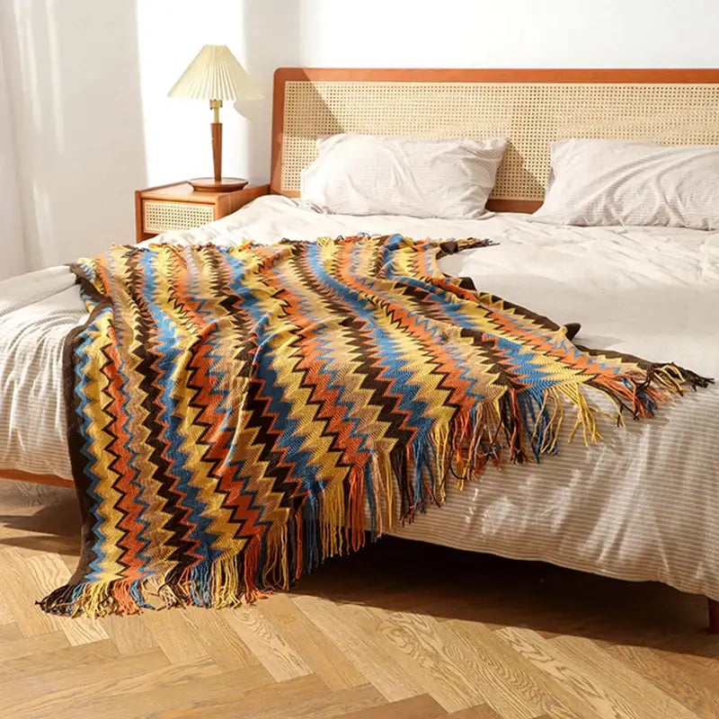 Boho knitted striped throw blanket by decorbites with vibrant zigzag pattern in yellow orange blue and brown with fringed edges