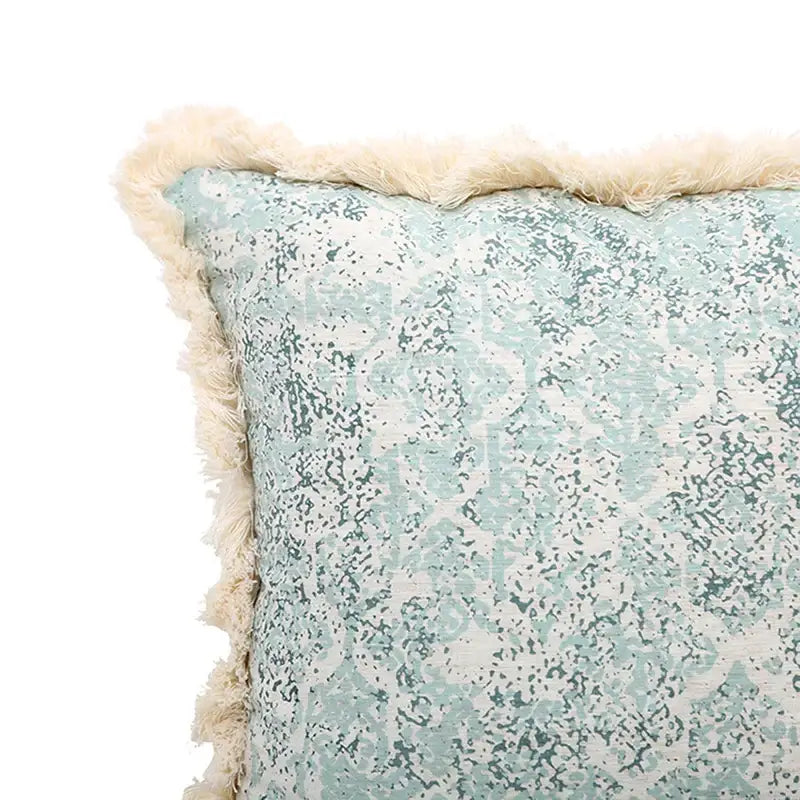 A square pillow cover with light blue and white distressed damask pattern and cream fringe for living room decorbites green tassel