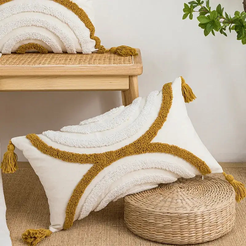 Cream-colored pillow cover with mustard-yellow tassels and textured boho loop tufted embroidery by decorbites