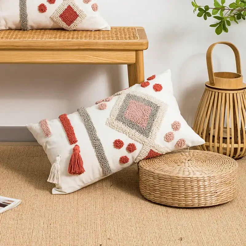 White rectangular boho loop tufted pillow cover with coral and gray embroidered geometric patterns and tassel accents