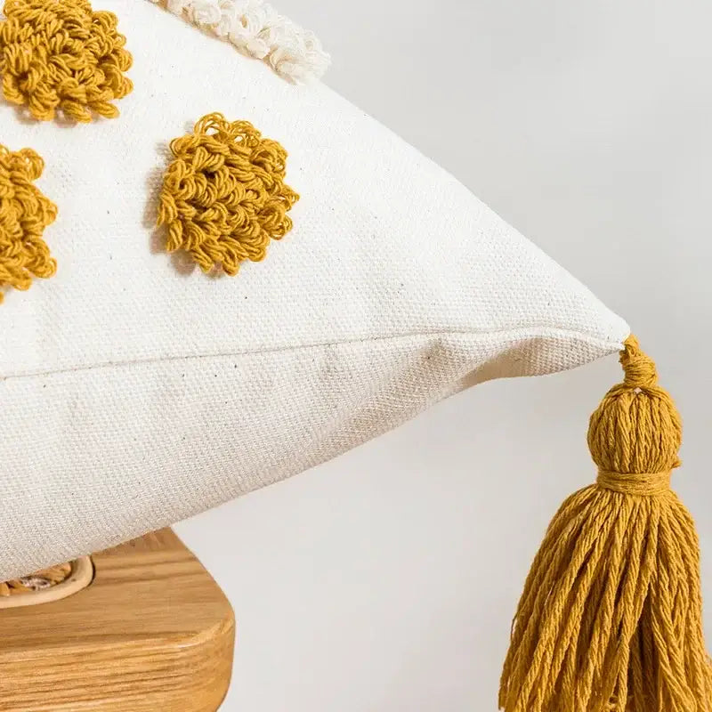 White pillow cover with mustard-yellow crocheted floral appliqués and tassel by decorbites boho loop tufted design