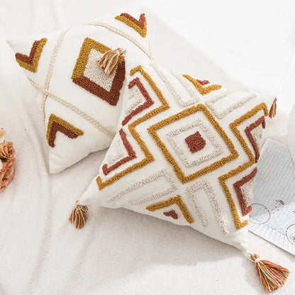 White throw pillow cover with mustard yellow and terracotta geometric embroidery and tassels from decorbites boho loop tufted collection