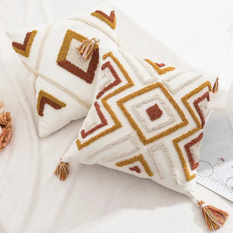 White throw pillow cover with mustard yellow and terracotta geometric embroidery and tassels from decorbites boho loop tufted collection