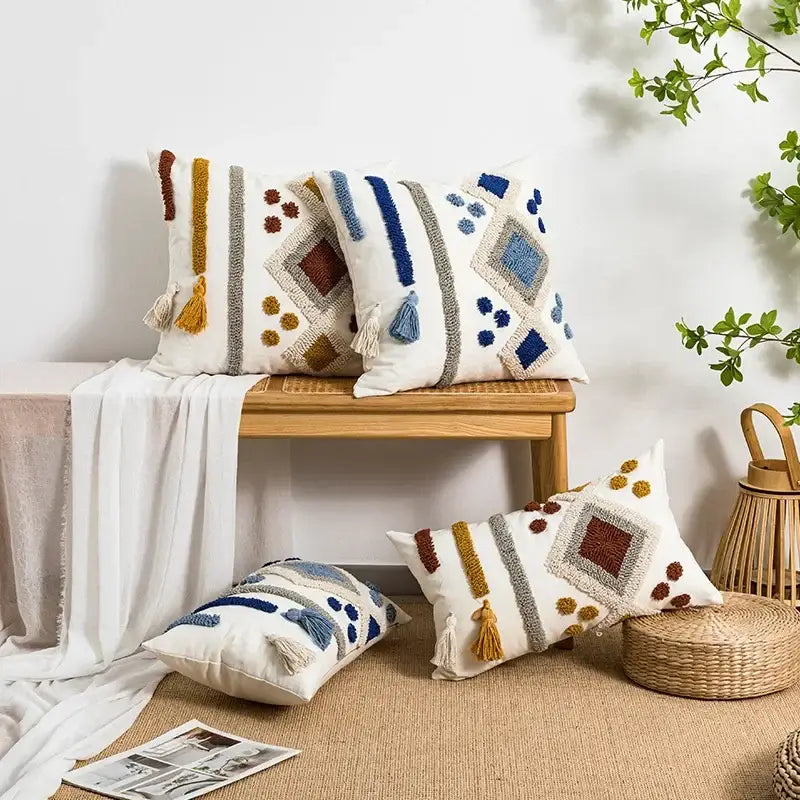White throw pillow cover with colorful geometric patterns and tassels in blue brown yellow and gray by decorbites boho loop tufted