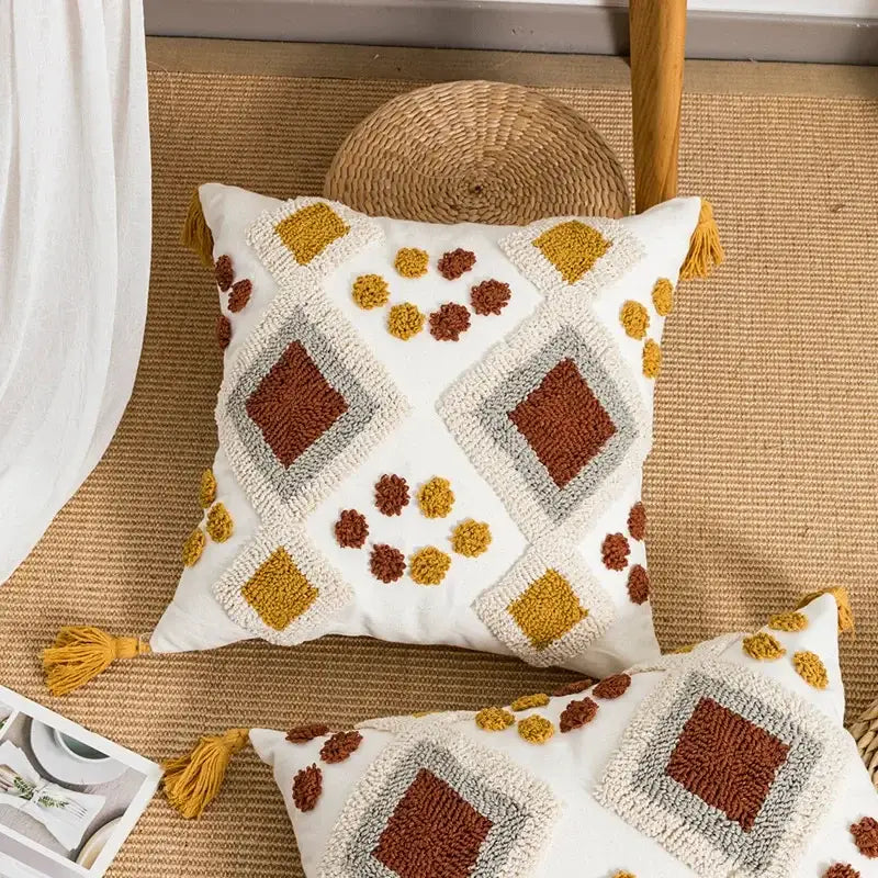 White pillow cover with mustard, terracotta, and gray geometric tufted squares and pom-poms decorbites boho loop tufted