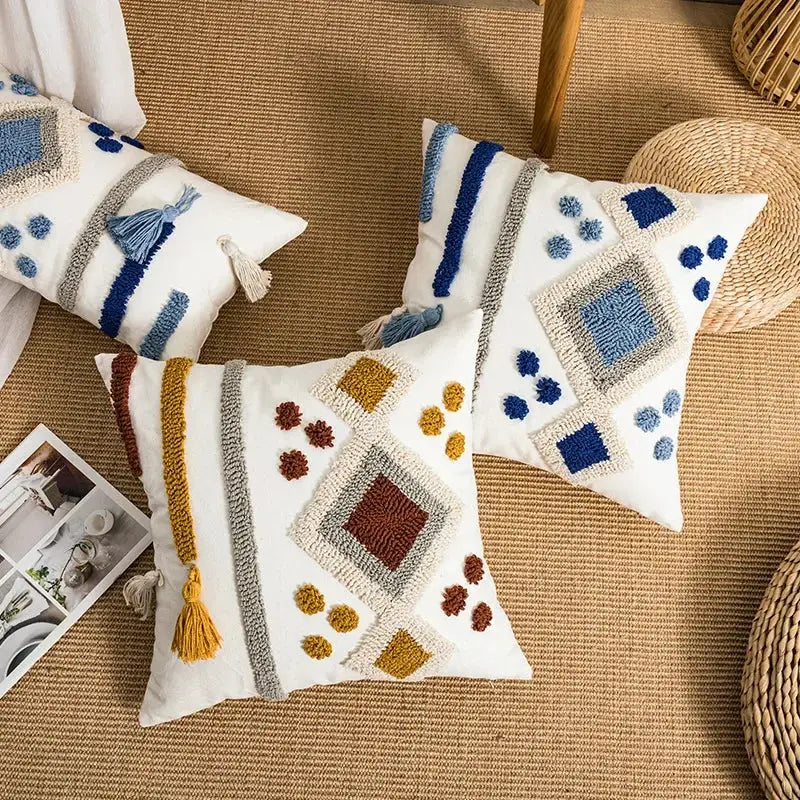 White throw pillow cover with boho loop tufted geometric patterns in blue gray and earthy tones accented with tassels decorbites boho loop