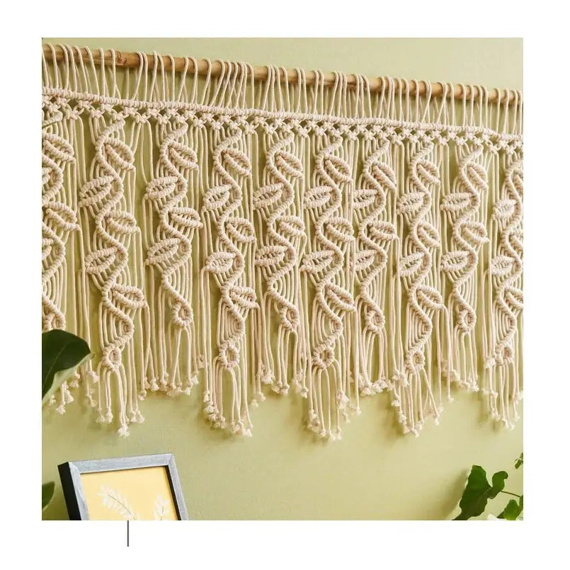 Cream-colored boho macrame tapestry curtain with intricate leaf pattern and fringe for bedroom decor by decorbites